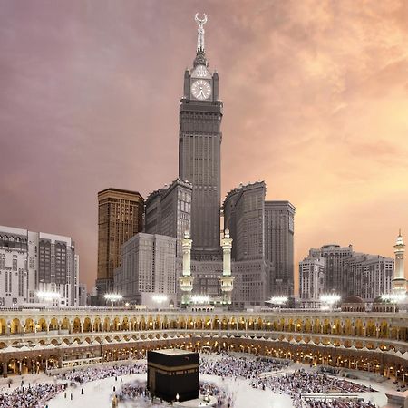 Swissotel Makkah La Meca Exterior foto The photo depicts the iconic Kaaba, located in Mecca, Saudi Arabia, surrounded by a large congregation of people performing the Hajj pilgrimage. In the background, there is a prominent clock tower building, which is part of the Abraj Al Bait complex.