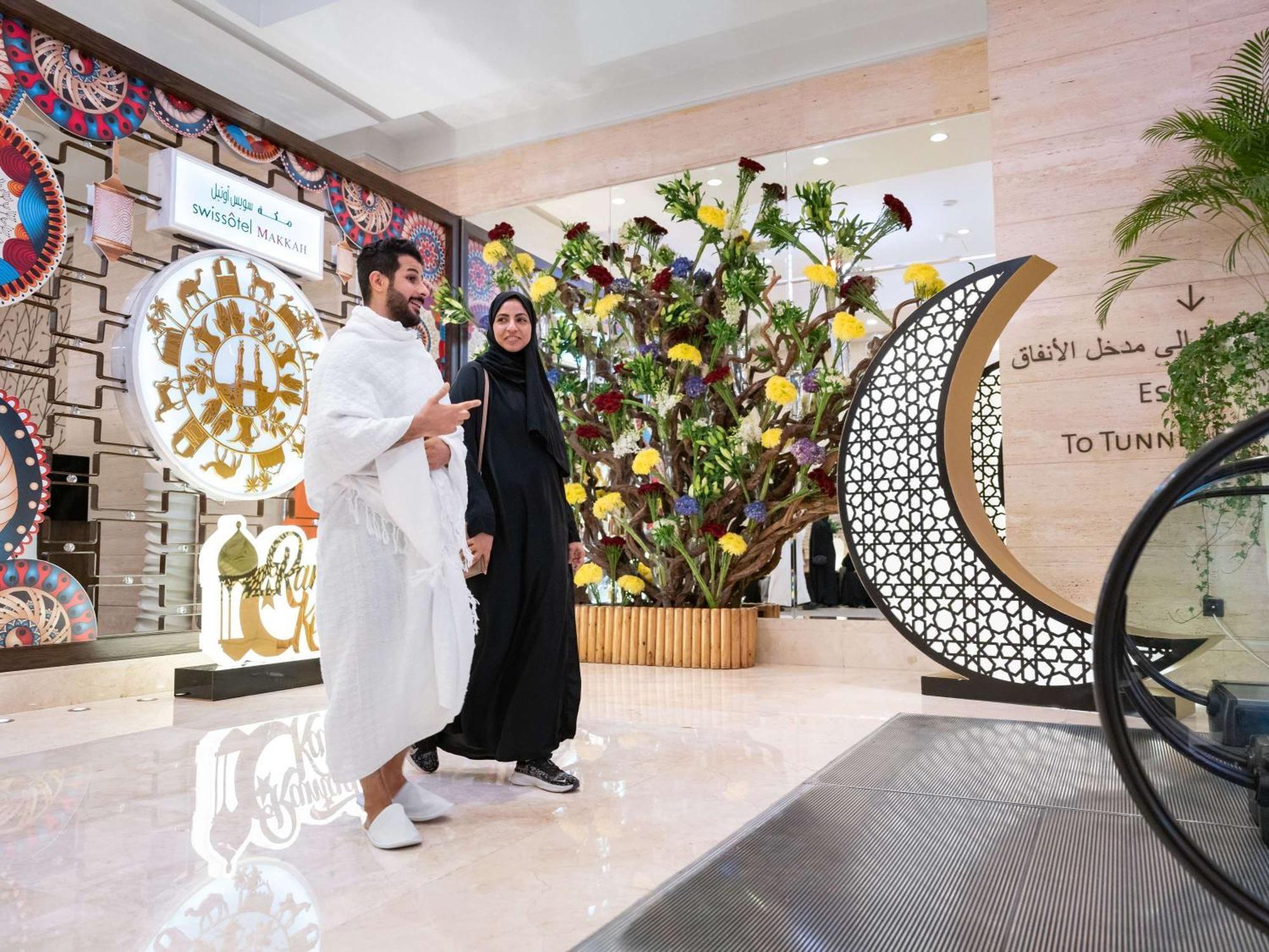 Swissotel Makkah La Meca Exterior foto The photo shows a modern, spacious interior, likely of a shopping mall or a public space. Two individuals are walking together; one is wearing a traditional white garment, while the other is dressed in a black abaya. In the background, there are deco